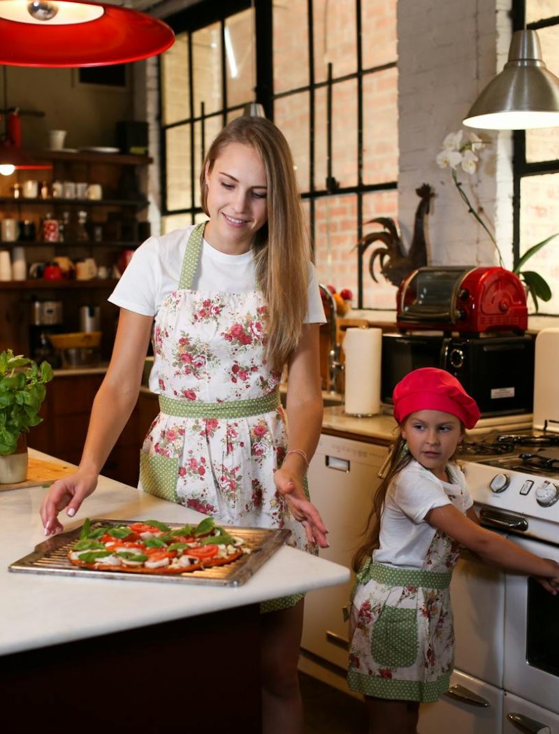 Une mère et sa fille qui vont faire cuire une pizza à la maison